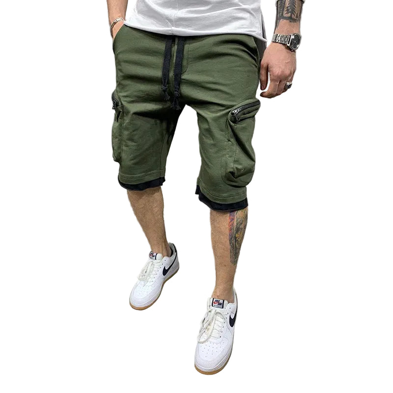 Studio presentation of the MONTQUANT Layered Fitness Cargo Shorts in Olive Green, highlighting the structured slim-fit cut, deep utility compartments, and white sneaker pairing.
