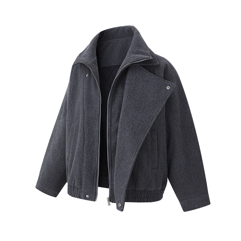 Front three-quarter view of the Montquant Modern Moto Jacket in a deep charcoal melange fabric, showcasing its asymmetric front zip, structured crossover collar layout, and clean minimalist outerwear silhouette.