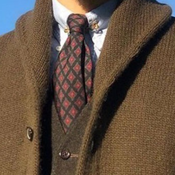 Detail shot of the integrated slouch-shawl collar profile of the MontQuant Knit Jacket layered over a classic collar and patterned necktie.