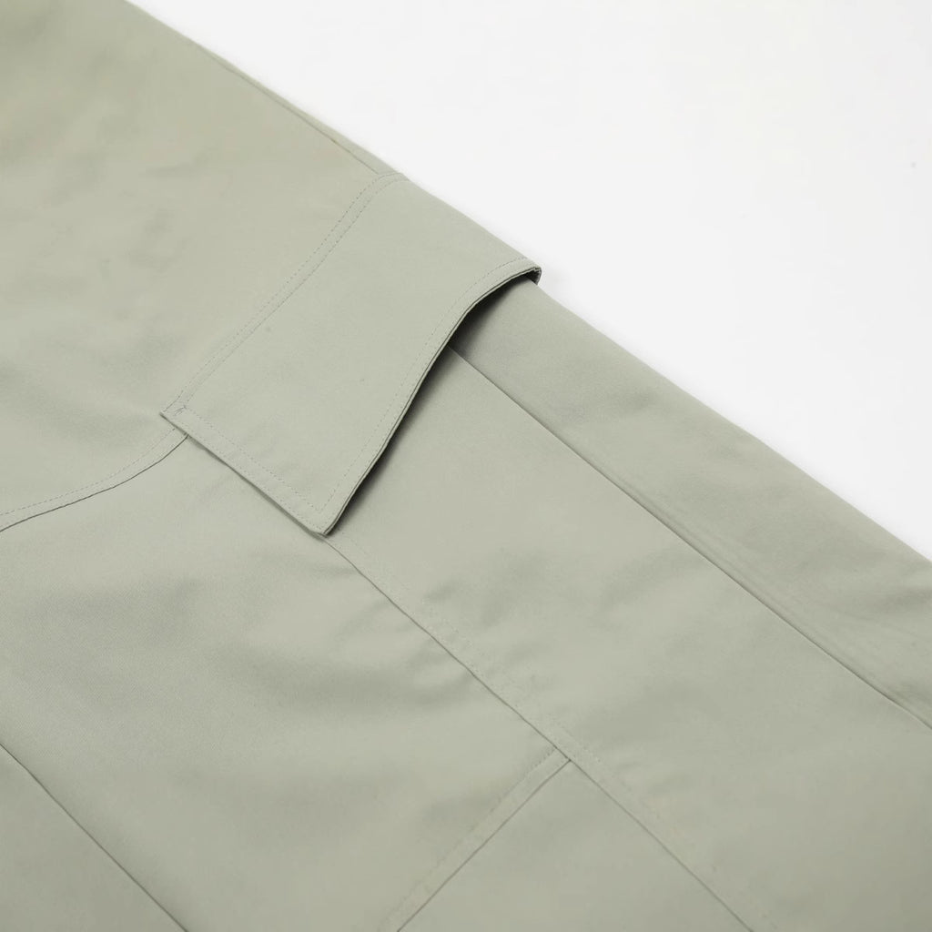 Detailed profile view of the flat-lay utility cargo pocket with an integrated fold-over flap on the MONTQUANT technical trousers.