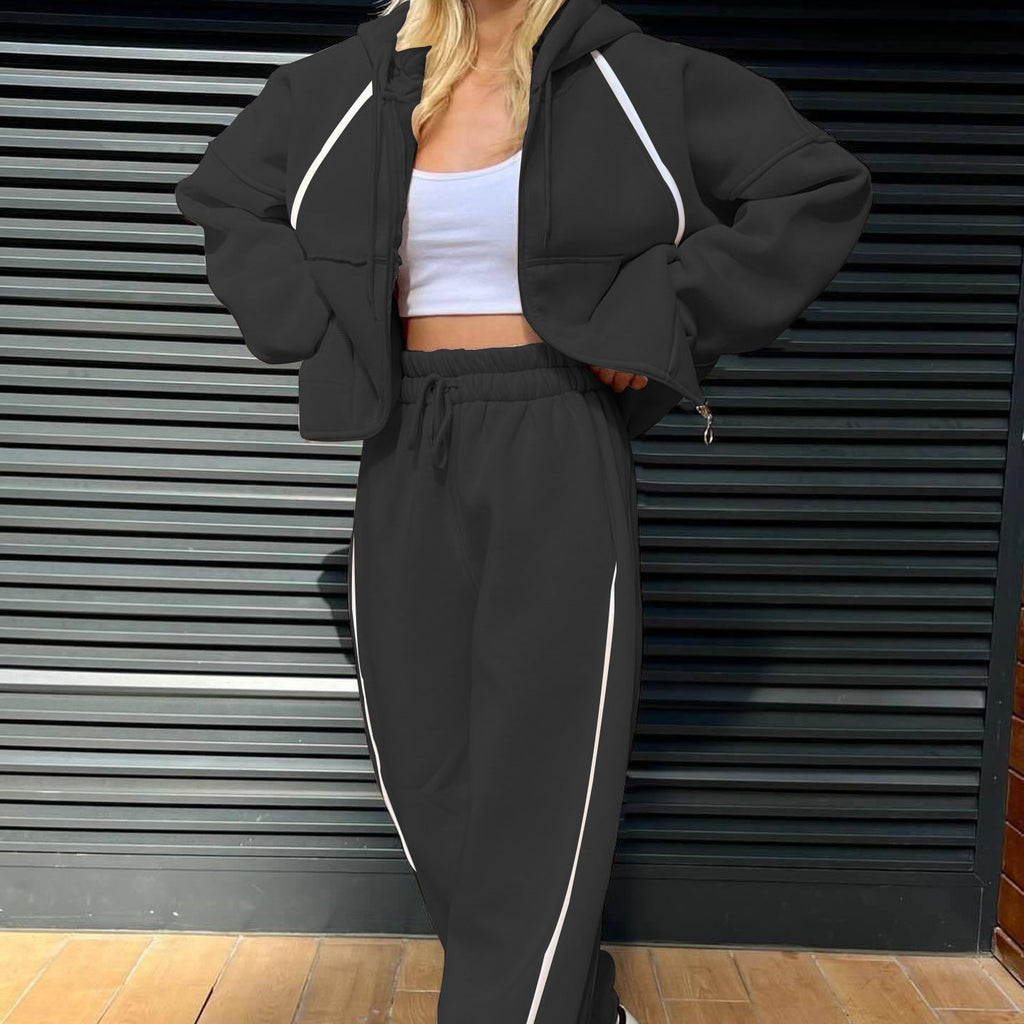 Front view of the minimalist two-piece tracksuit set in matte black, accented by a stark white contrast stripe along the outer seams.