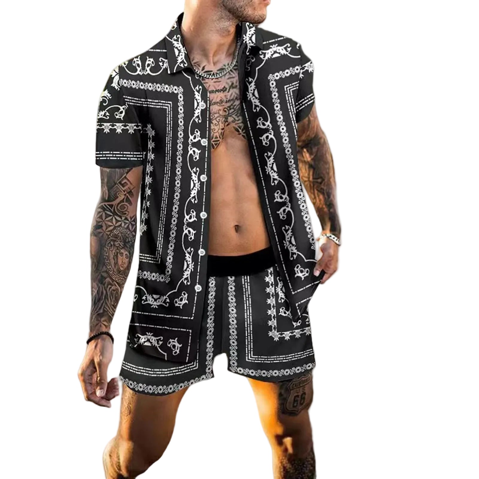 Man modeling the MONTQUANT two-piece resort set on a beach background, featuring an intricate dark grey and black baroque graphic layout.