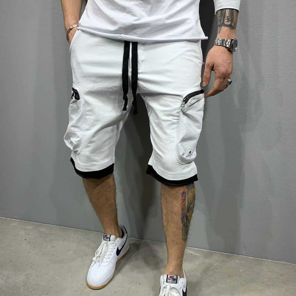 Front view of the MONTQUANT Layered Fitness Cargo Shorts in White, detailing the sharp visual contrast of black zippers, black drawcords, and black layered mesh hems.