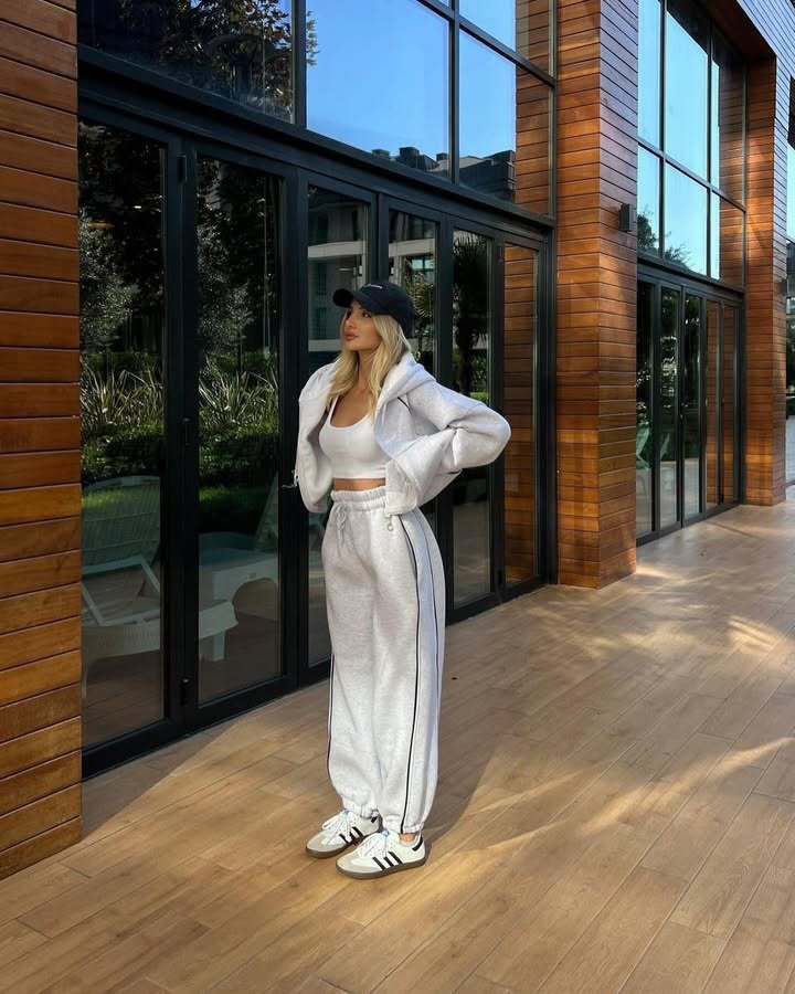 Three-quarter profile of a model showcasing the relaxed silhouette and structural fit of the light gray fleece lounge set with contrast side paneling.