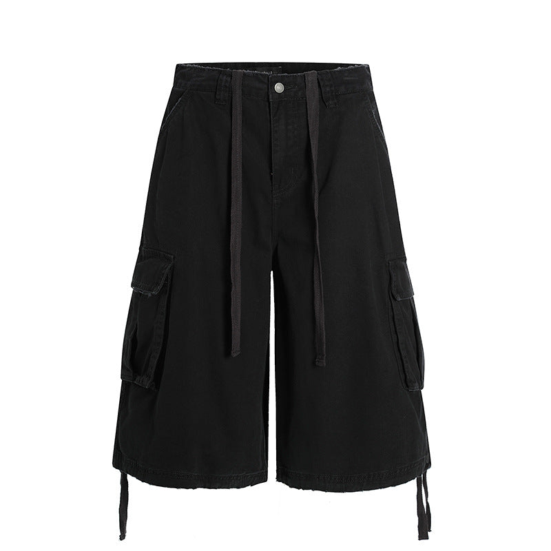 Front view of the Montquant Utility Workwear Short in a solid matte black, showcasing its wide-leg relaxed silhouette, prominent side cargo pockets, and extended tonal drawstring accents.