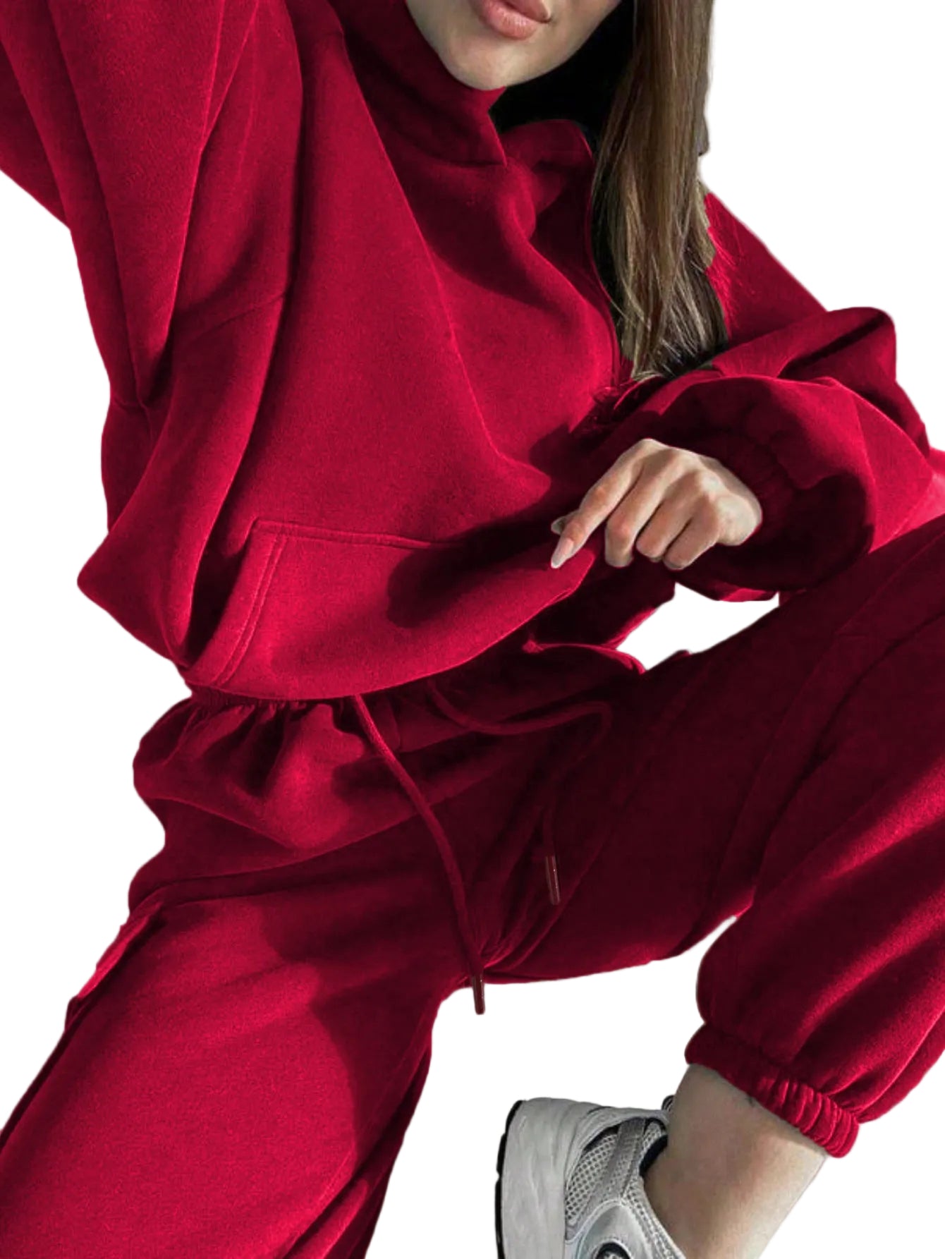 A woman wearing a vibrant crimson red matching hoodie and jogger lounge set while seated.
