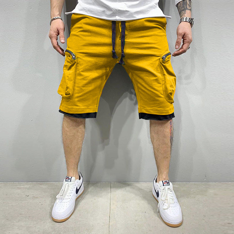 Front alignment of the MONTQUANT Layered Fitness Cargo Shorts in Mustard Yellow, emphasizing the contrast between the rich yellow body panels and the black mesh layered trim.