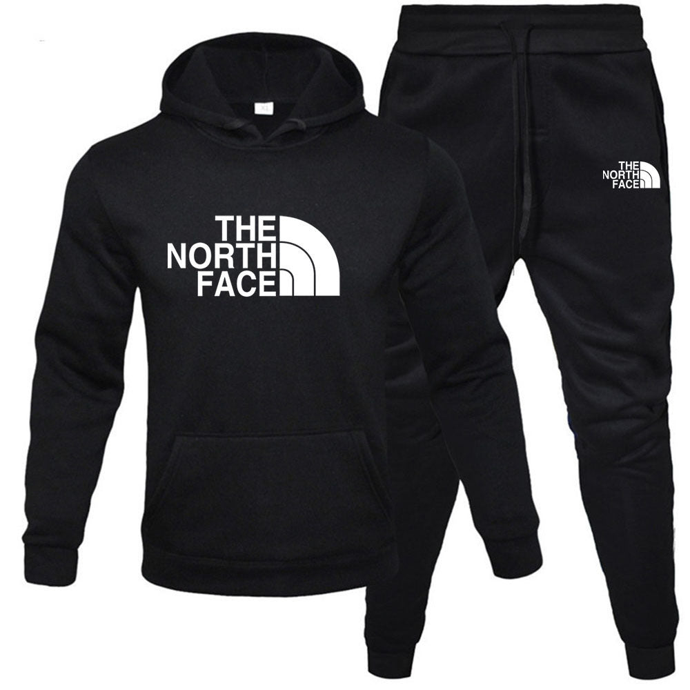 Front view of the MONTQUANT Fleece Pullover Tracksuit Set in monochrome black, showcasing the matching hoodie and joggers with contrast white graphic logos on the chest and thigh.