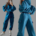 Front and back view of a model in a vibrant steel blue matching pullover hoodie and cargo trousers set.