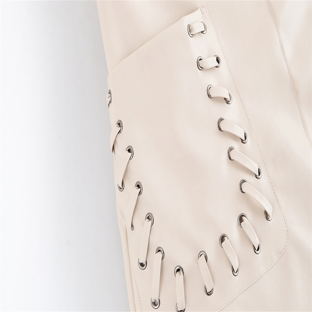 Detailed close-up view of the metal grommets and criss-cross string tie detailing on the beige skirt