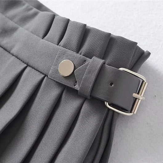 Close-up view of the waistband on the dark grey skort, highlighting the integrated belt loop, gold-tone button hardware, and buckle.