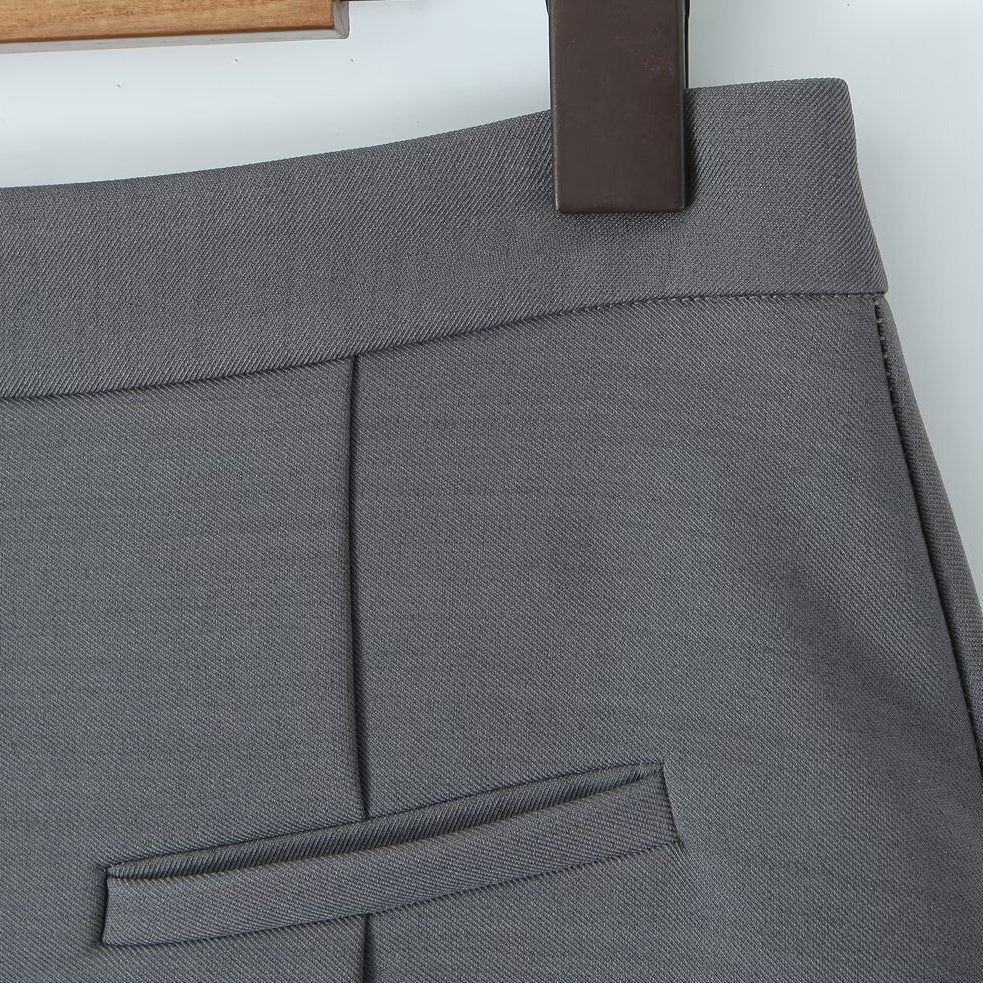 Close-up shot of the discrete faux welt pocket decoration and precision stitching on the gray skort