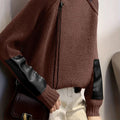 Front view of woman wearing the MONTQUANT Asymmetric Patchwork Knit Pullover in brown with black faux-leather sleeve accents.