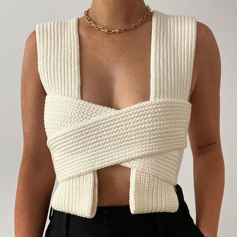Model front view wearing the ribbed cross-woven wrap top in off-white styled with dark trousers.