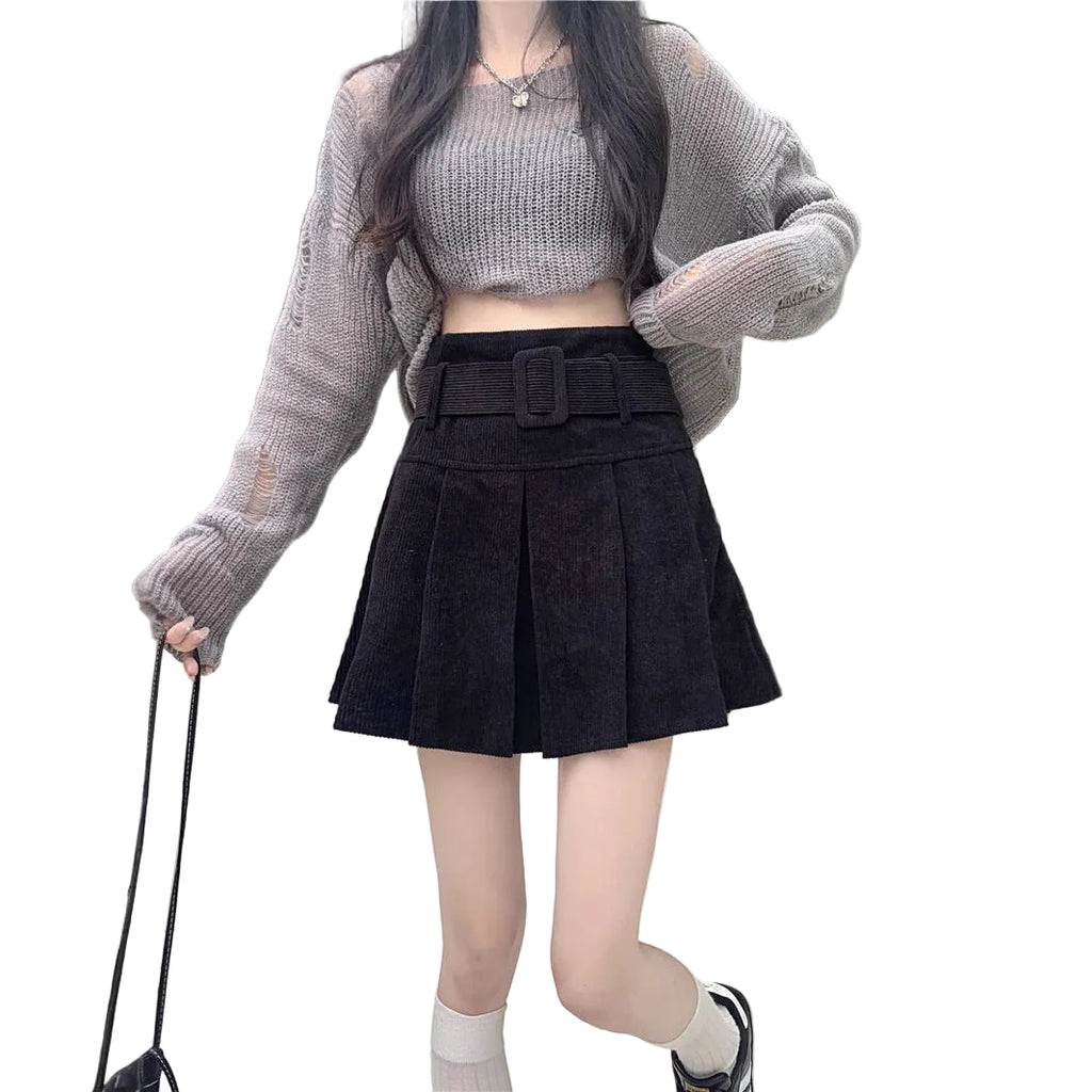 On-model shot featuring the black color variant of the skirt paired with a grey long-sleeve crop top and white socks.