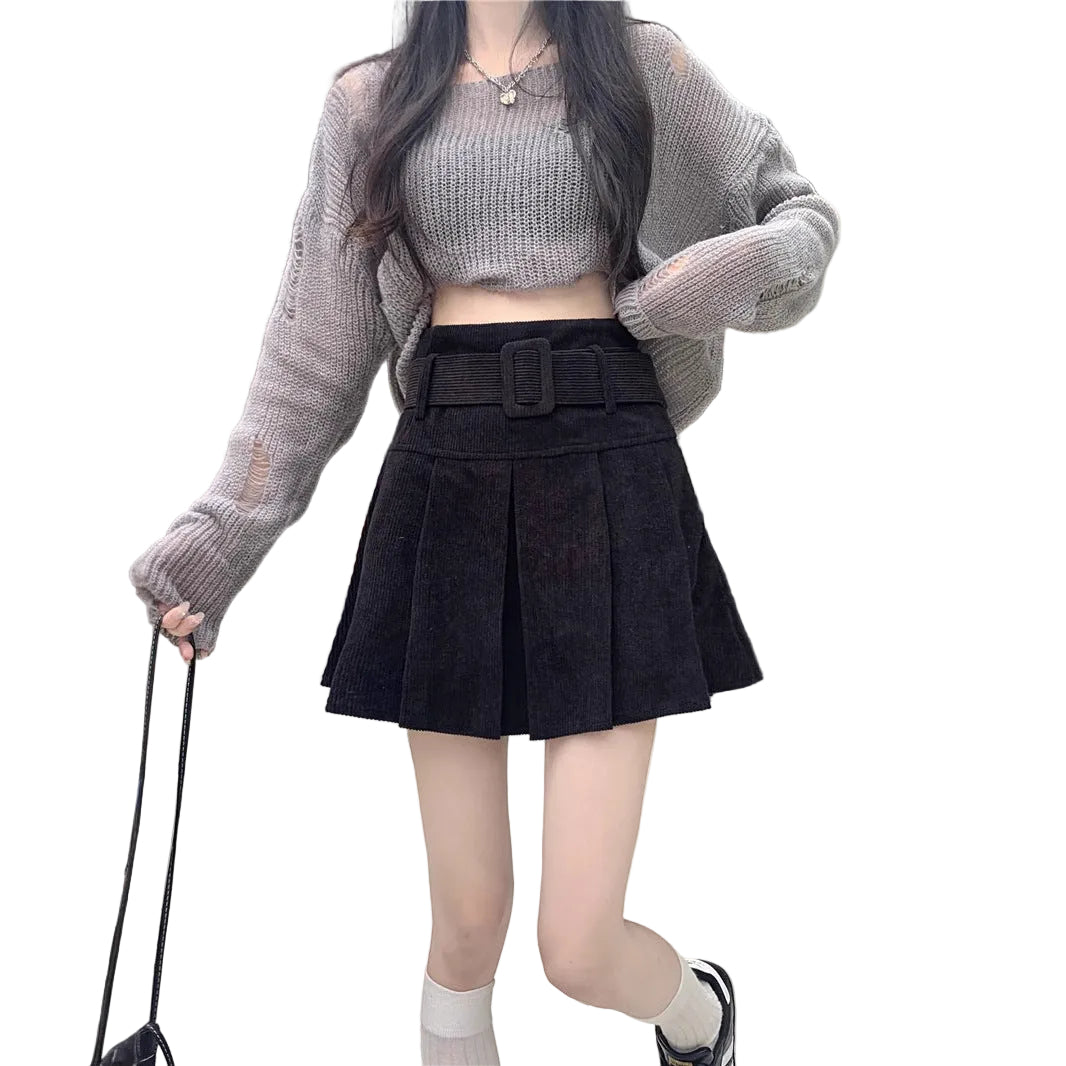 On-model shot featuring the black color variant of the skirt paired with a grey long-sleeve crop top and white socks.