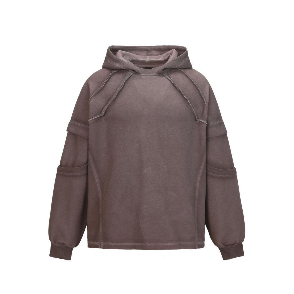 Front view of the Montquant Distressed Patchwork Hoodie in a washed espresso brown hue, showcasing its heavy-weight structural hood, raw-edge patchwork paneling, and drop-shoulder design.