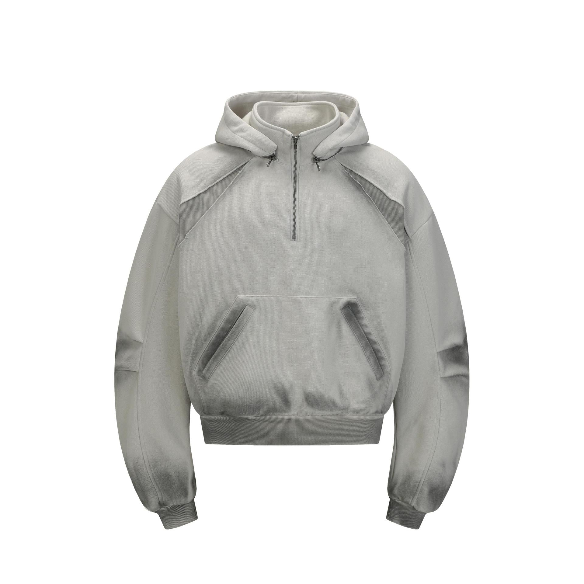 Front view of the Montquant Heavyweight Half-Zip Hoodie in a soft heather grey colorway, highlighting its metal neckline zip, front kangaroo pocket, and unique distressed seam piping.