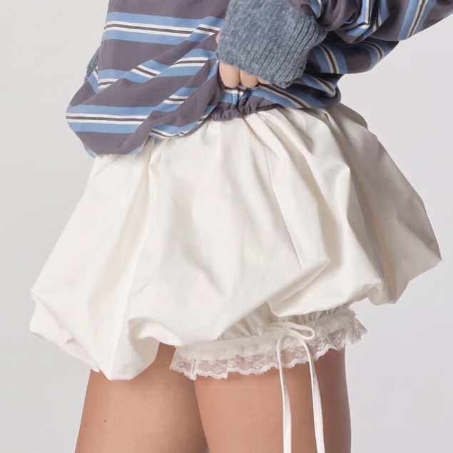 Model wearing a white puff tiered fluffy mini skirt with matching lace details